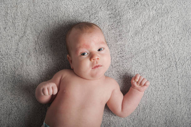 a baby laying on a gray surface