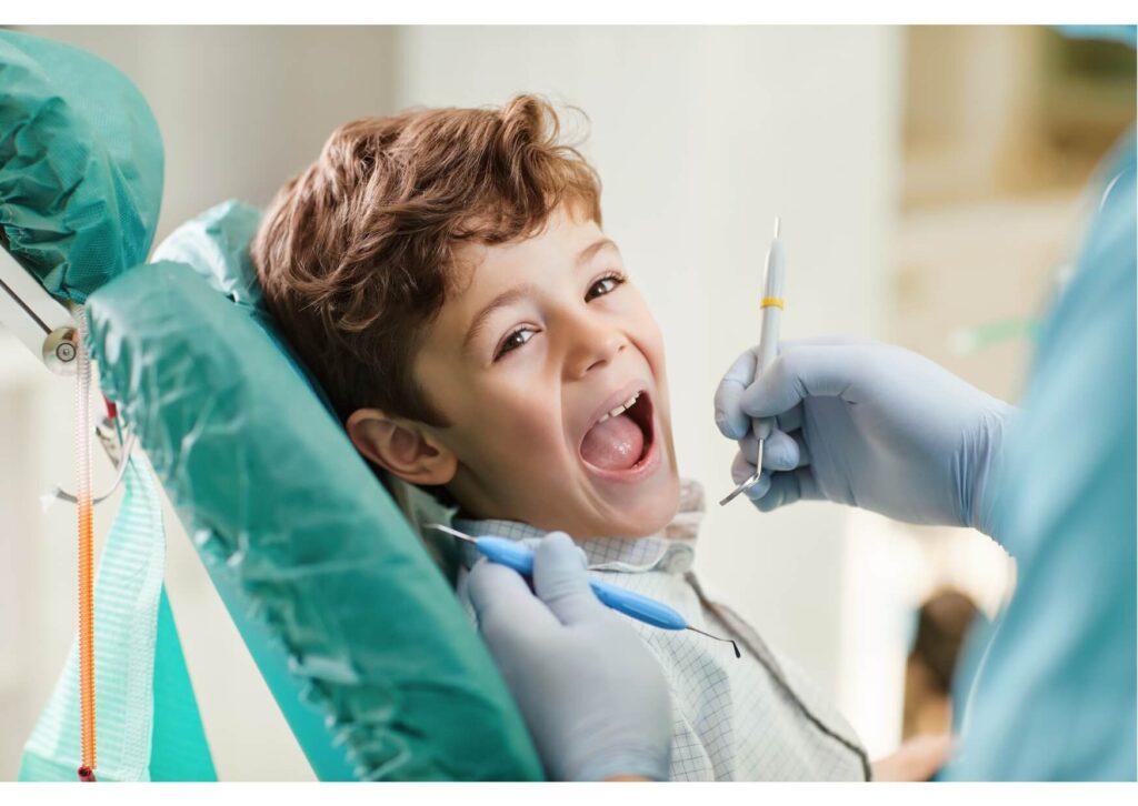 Young child smiling during a comfortable visit with a pediatric dentist for a routine dental checkup
