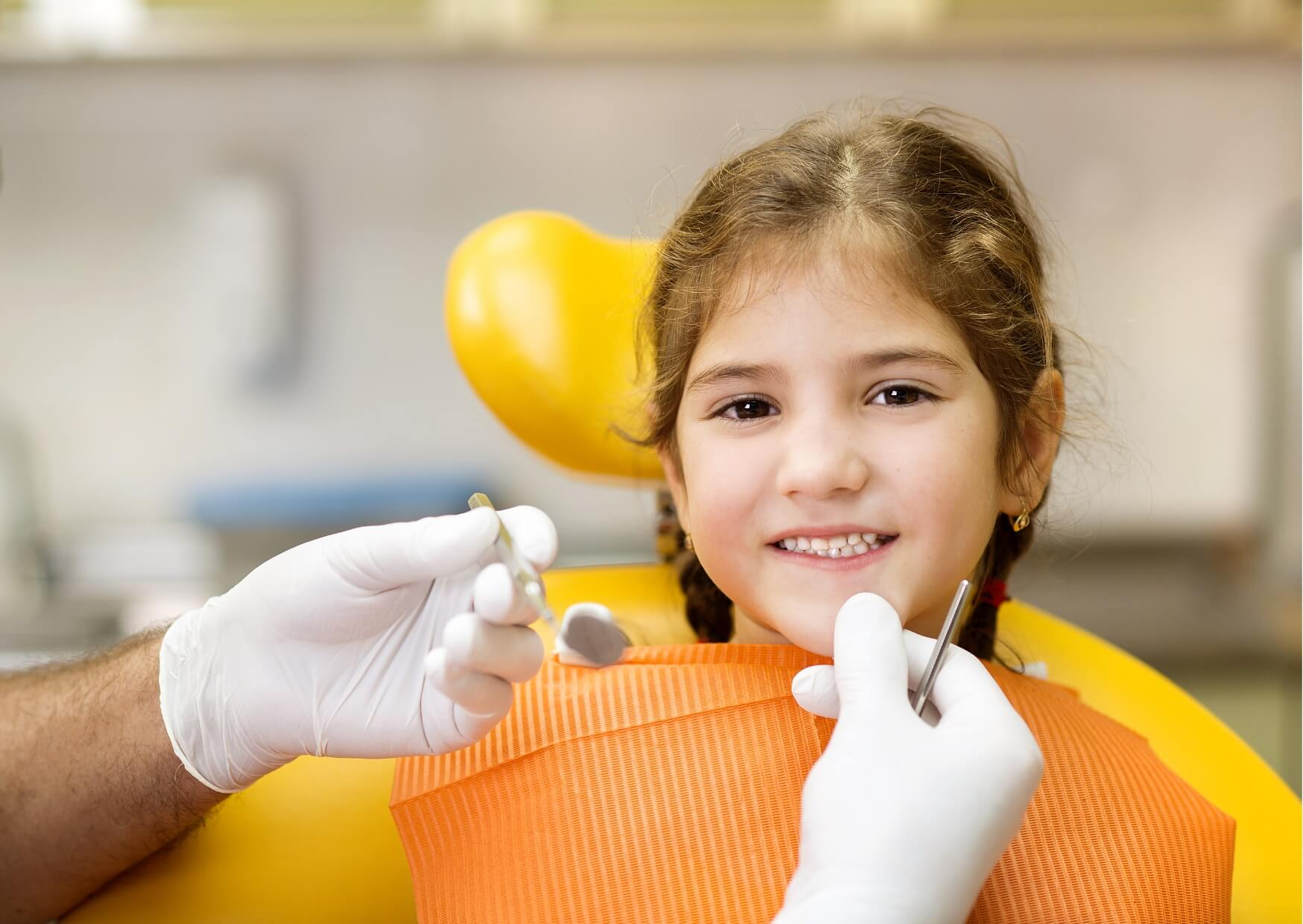 Smiling child at a pediatric dental visit before dental sealant treatment, emphasizing preventive care for healthy developing teeth.